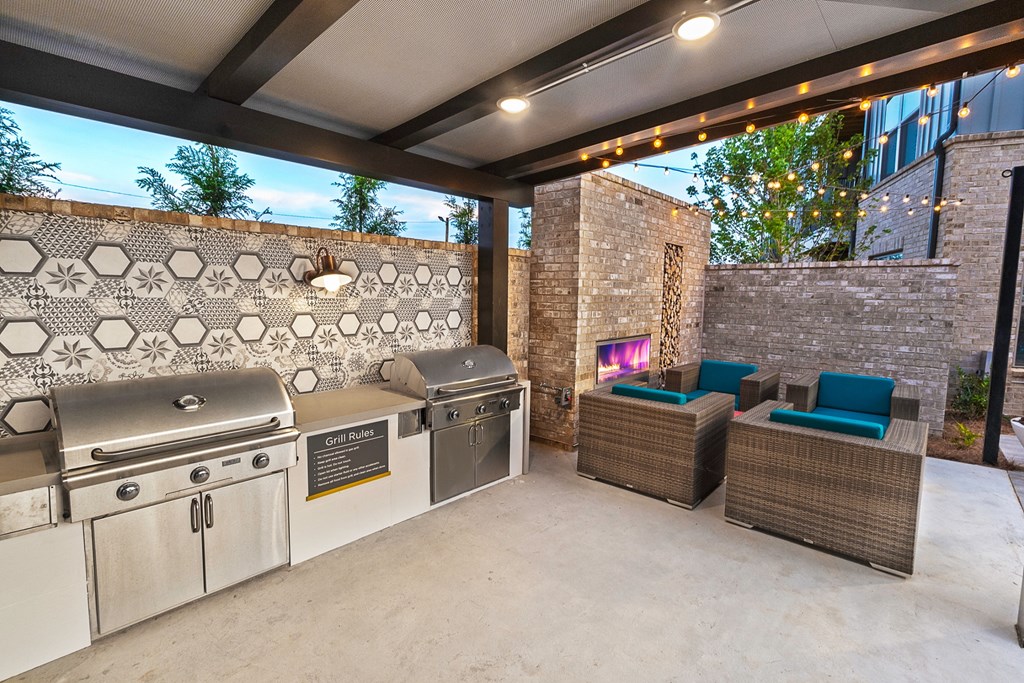 a patio with a barbecue grill and a table with chairs