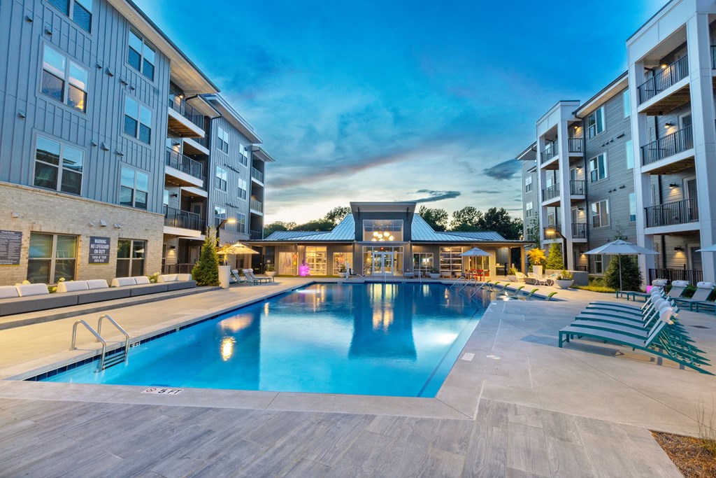 an apartment building with a swimming pool in front of it