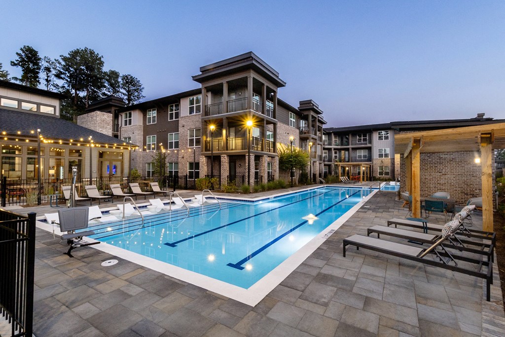 a swimming pool with lounge chairs and a building in the background