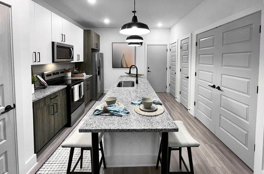 an open kitchen and dining room with a marble counter top