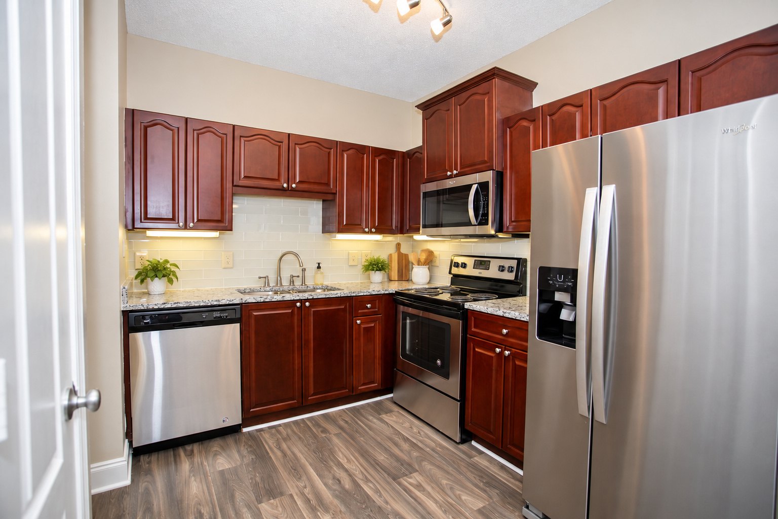 A kitchen with brown cabinets and a stainless steel refrigerator.