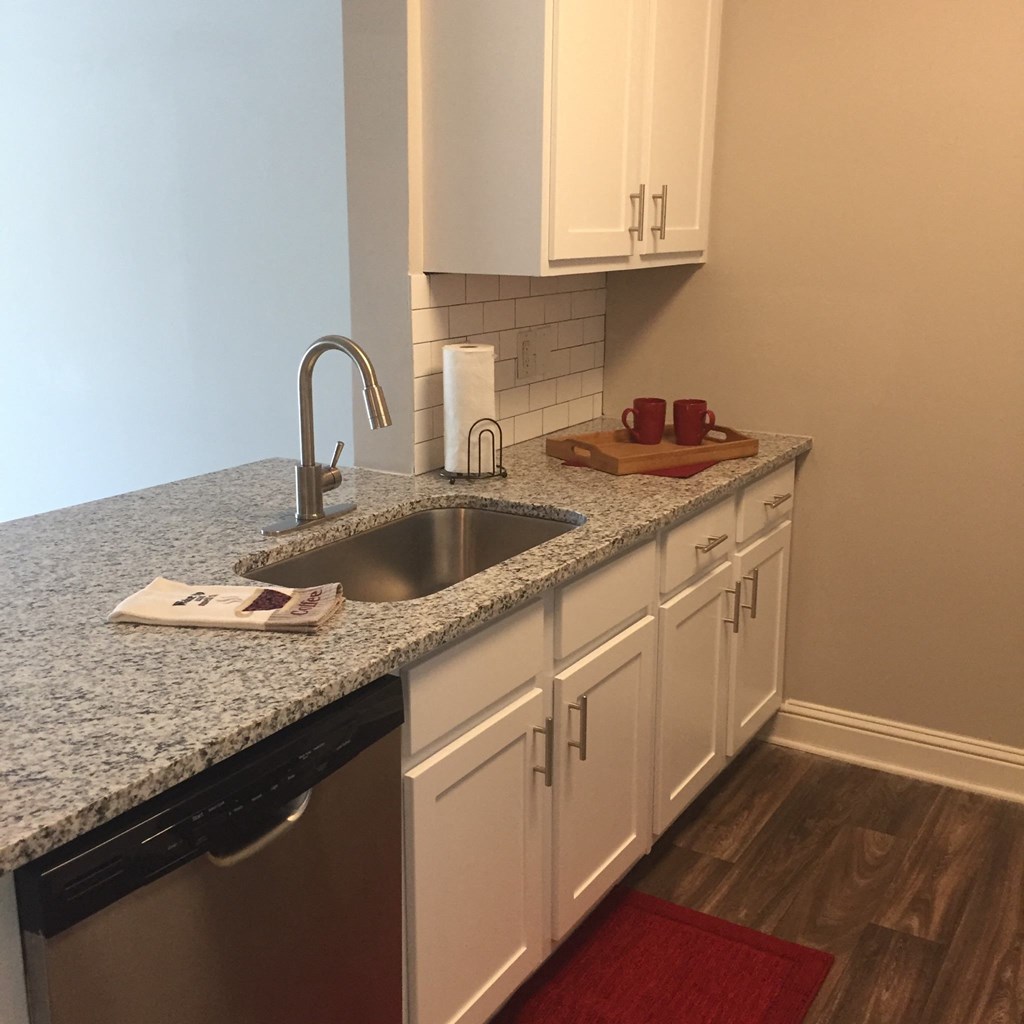 a kitchen with white cabinets and a granite counter top at Lullwater at Calumet, Newnan