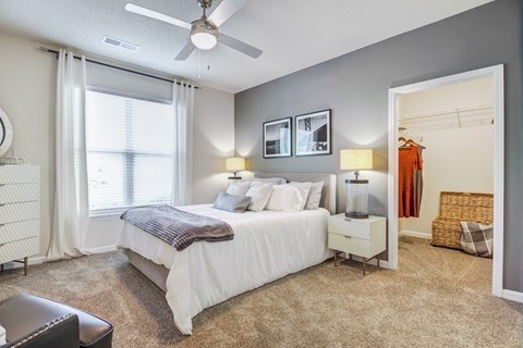 A bedroom with a large bed and a ceiling fan.