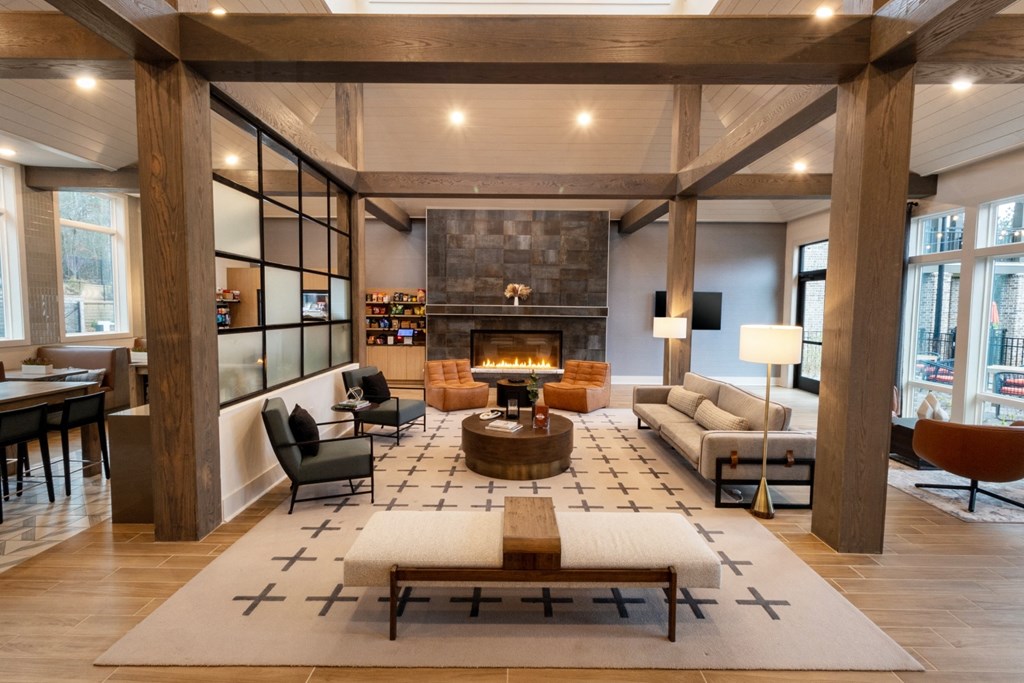 the lobby of a hotel with a living room and a fireplace