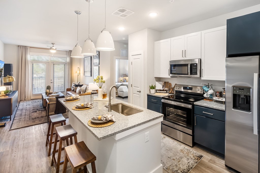 an open kitchen and living room with a large island and a dining room table