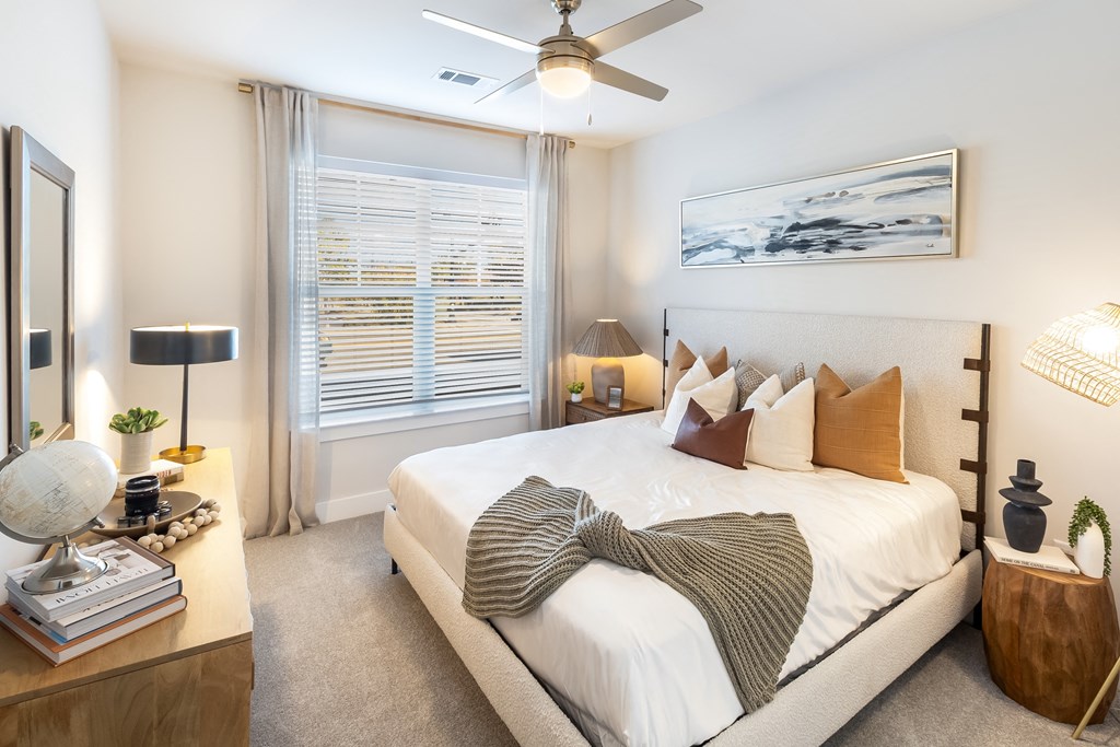 a bedroom with a large bed and a ceiling fan