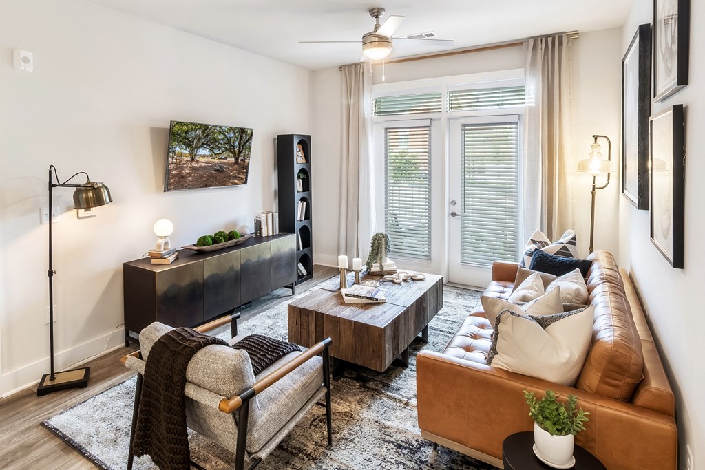 a living room with a leather couch and a tv