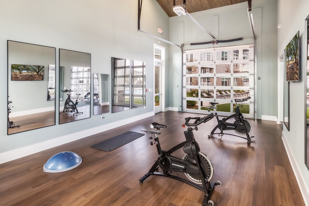 a home gym with exercise bikes and mirrors on the wall