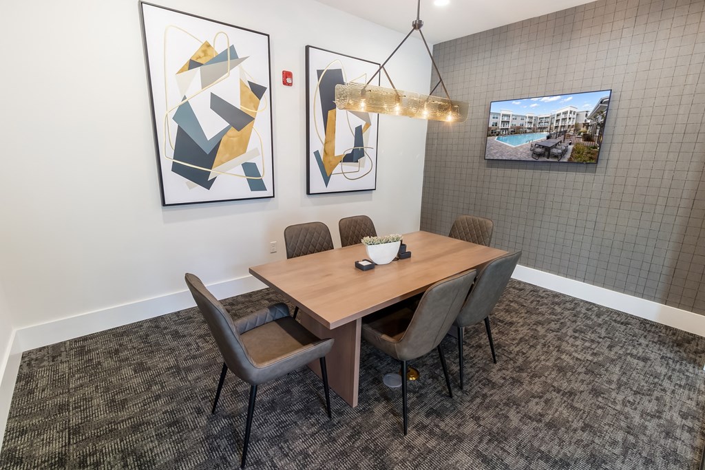 a dining room with a wooden table and chairs and paintings on the wall