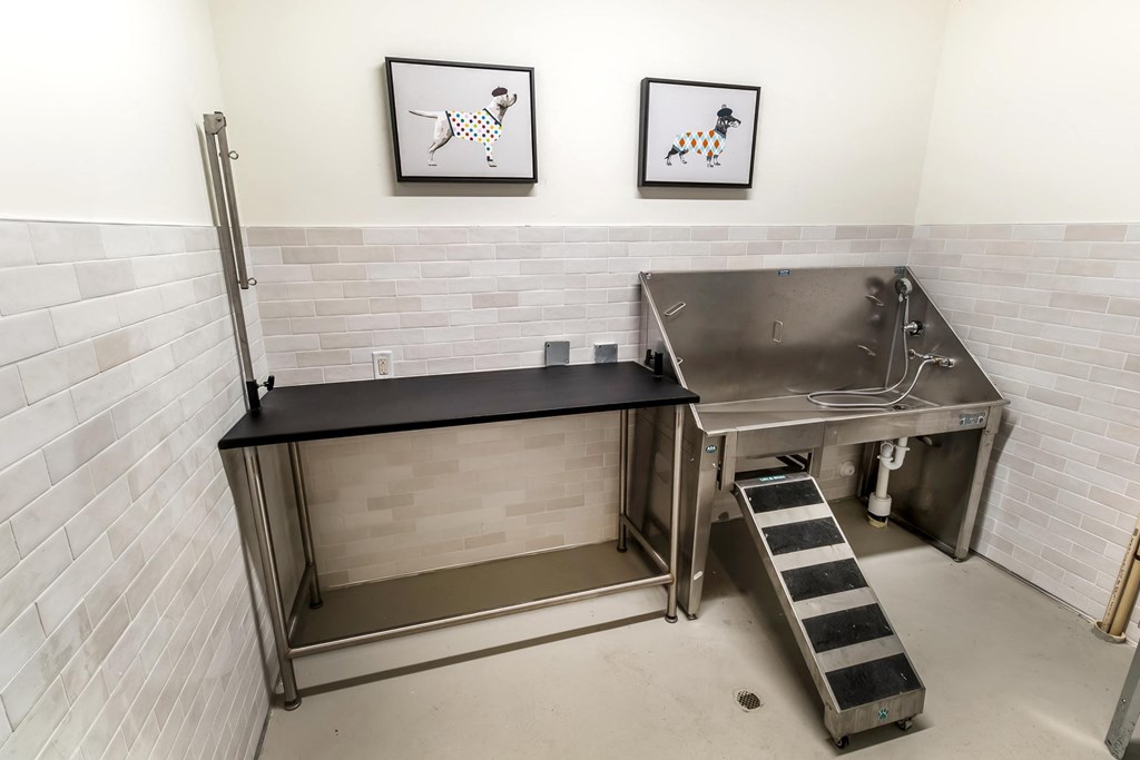 a large stainless steel sink in a room with two pictures on the wall
