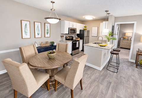 A kitchen with a dining table and chairs.