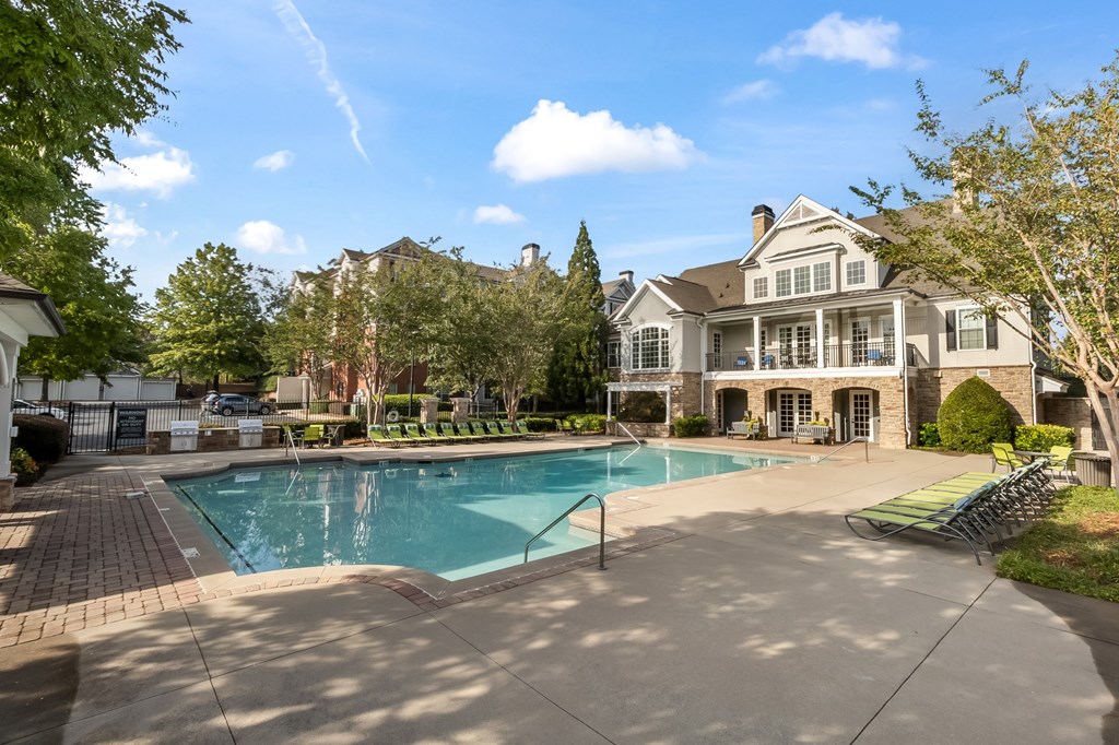 a swimming pool with a house in the background at The Pointe at Suwanee Station, Suwanee, 30024