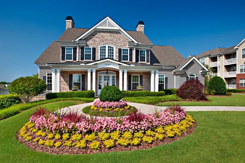 A large house with a flower bed in front.