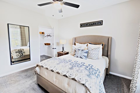 A bedroom with a large bed and a ceiling fan.