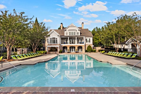 A large house with a pool in front of it.