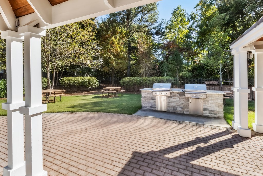 A patio with a white column and a stone wall.