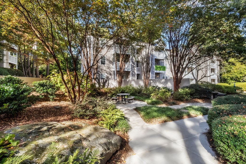 A park with a walking path and a bench.