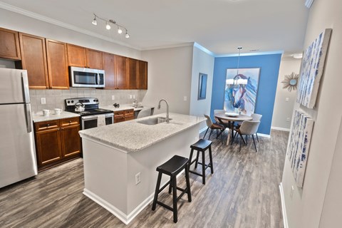 a kitchen with a large island and a dining room with a table and chairs