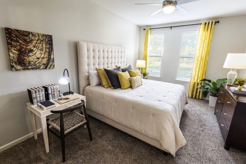 a bedroom with a white bed and yellow curtains