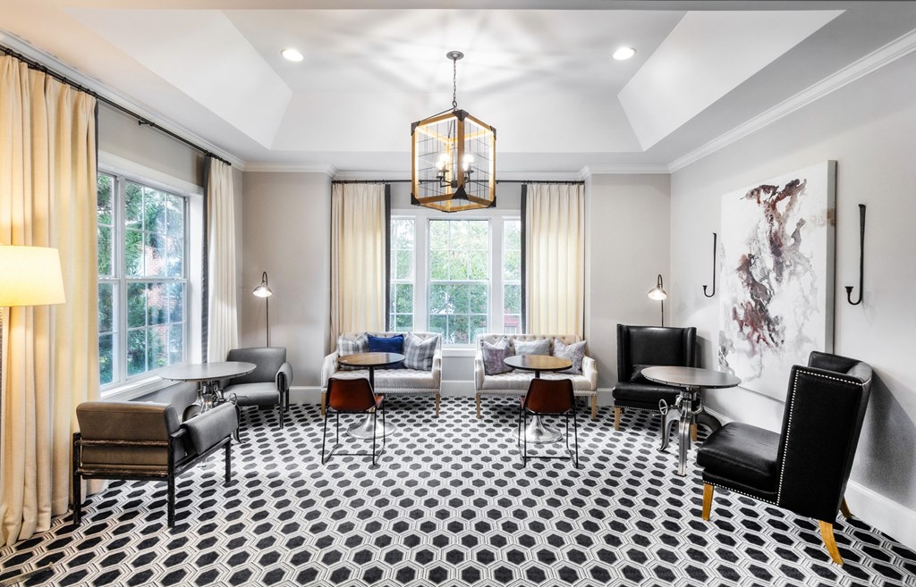a living room with chairs and tables and a large window at The Pointe at Suwanee Station, Suwanee, GA