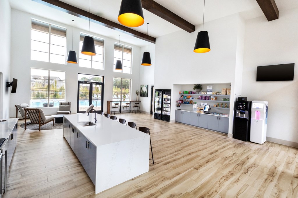 a communal area with a kitchen and dining area and large windows