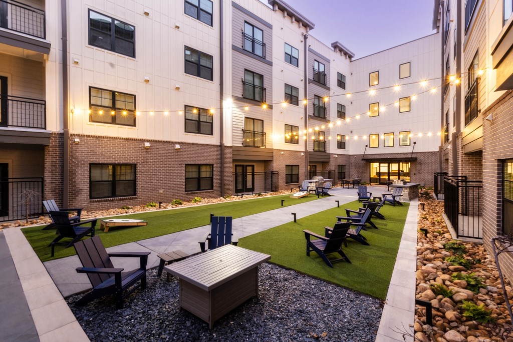 an outdoor courtyard with tables and chairs at the grove apartments