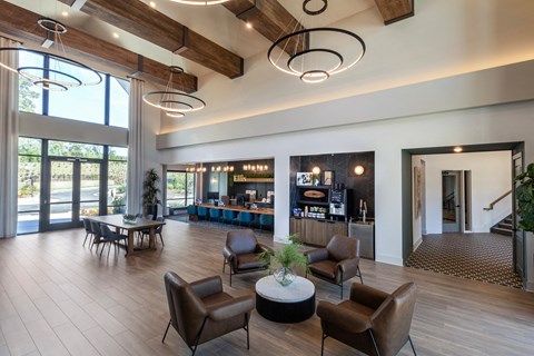 a large lobby with chairs and tables and a bar