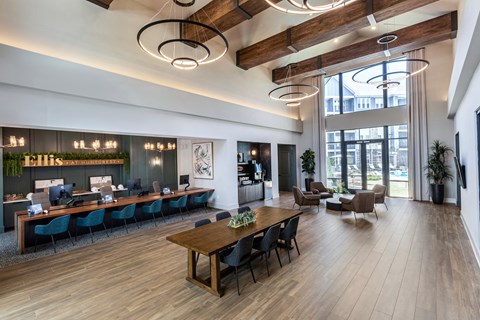 the lobby of a hotel with a reception desk and a table with chairs