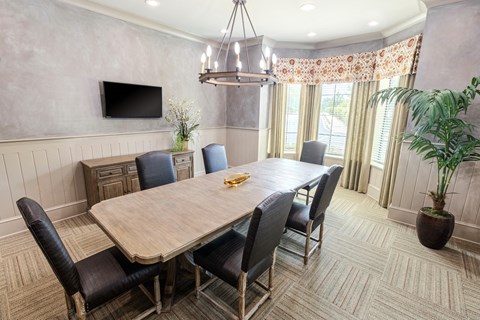 a dining room with a wooden table and chairs and a television
