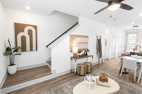 a living room with a table and a ceiling fan