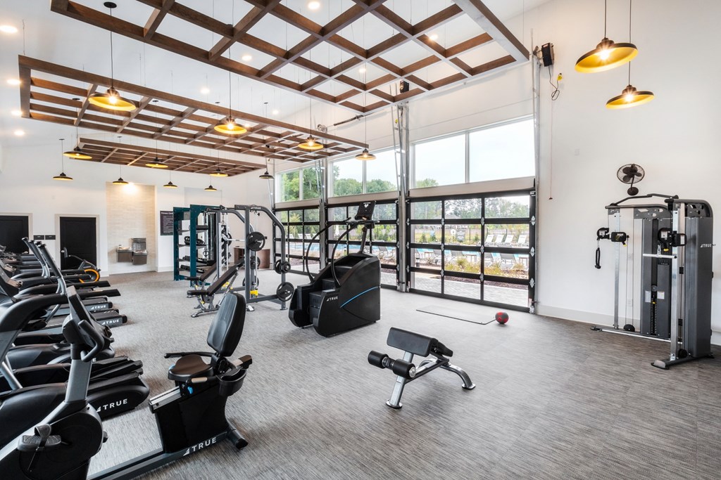 a gym with treadmills and other exercise equipment and windows