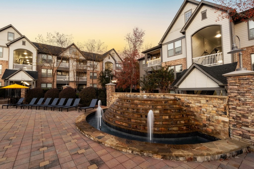 a courtyard with a fountain in front of some houses at The Reserve at Sugarloaf Apartments, Duluth, GA