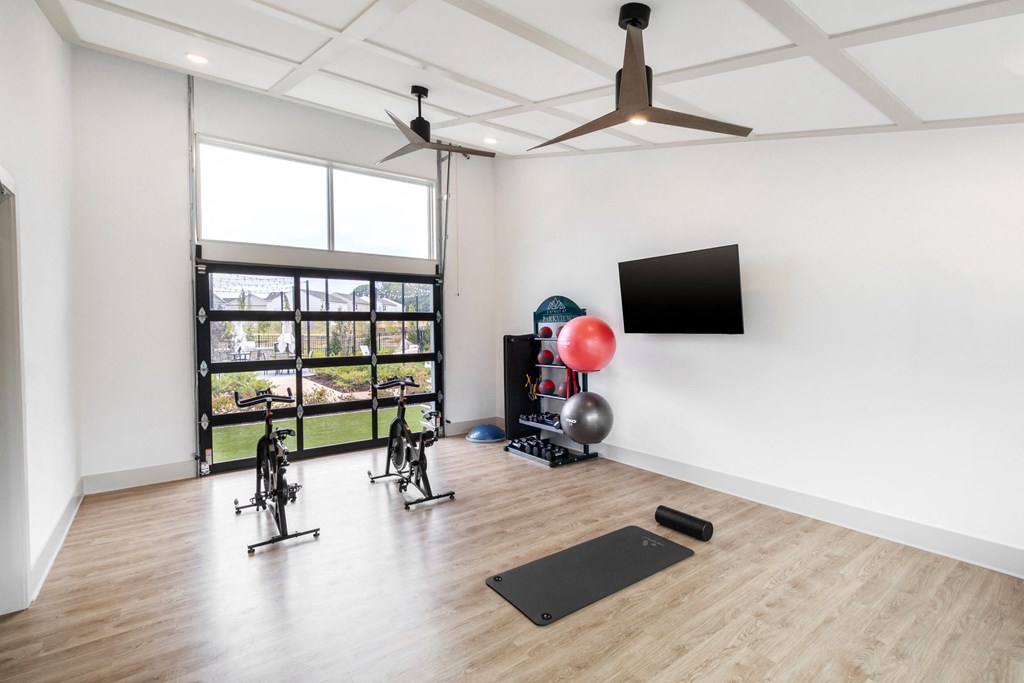 the living room with yoga equipment and a large window
