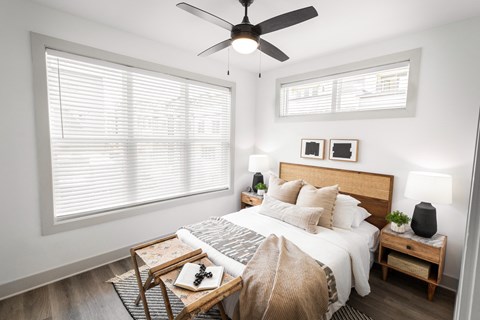 a bedroom with a large bed and a ceiling fan