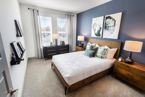 a bedroom with a bed and two windows