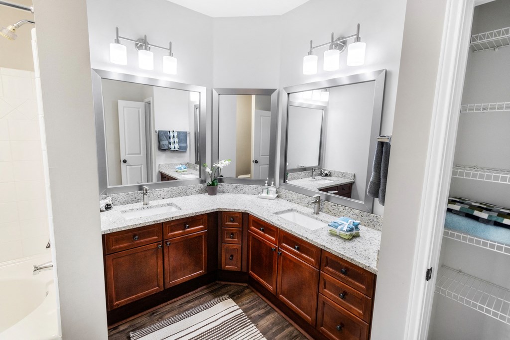 a bathroom with two sinks and three mirrors at The Pointe at Suwanee Station, Suwanee, Georgia