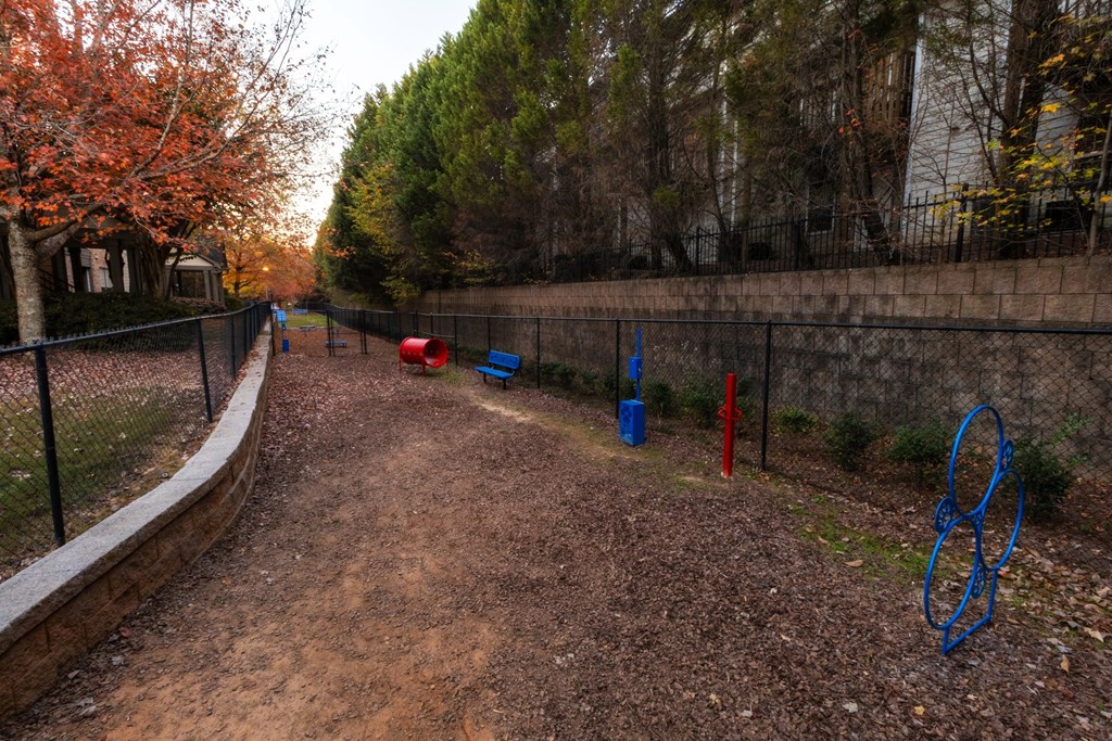 a path in a park with playground equipment and a fence at The Reserve at Sugarloaf Apartments, Duluth, GA, 30097