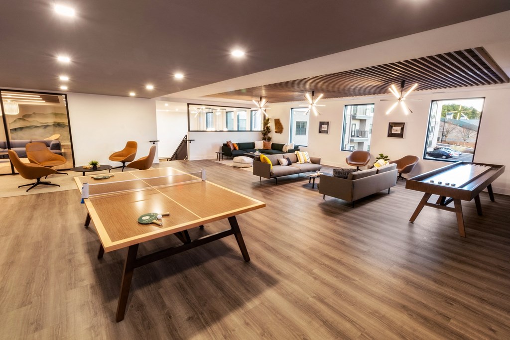 a large living room with a ping pong table and couches