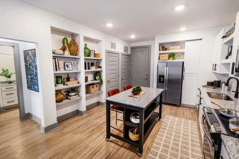 a kitchen with a center island and a stainless steel refrigerator