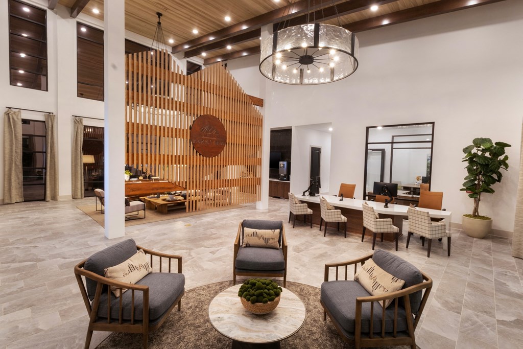 the lobby of a hotel with chairs and tables