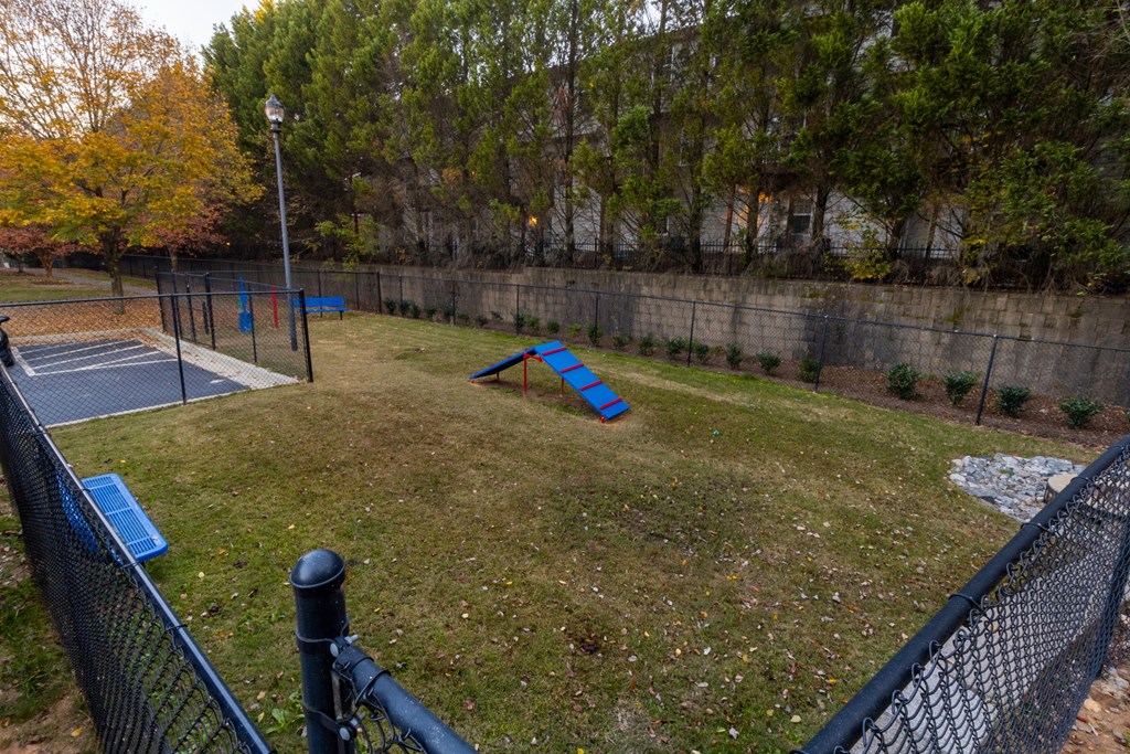 a playground with a seesaw in the middle of a yard at The Reserve at Sugarloaf Apartments, Duluth, GA