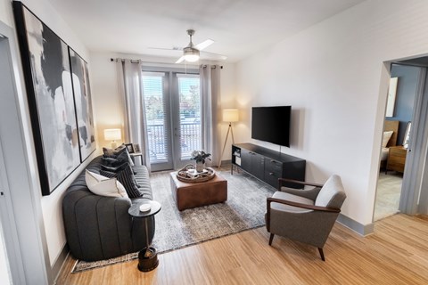 a living room with a couch and a chair and a tv