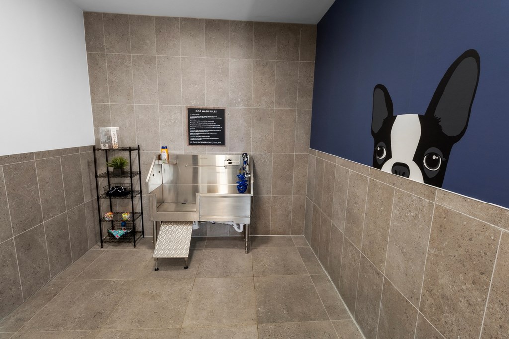 a bathroom with a sink and a mural of a dog on the wall