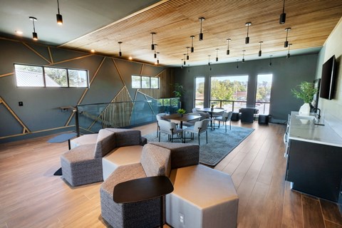 a living room with couches tables and chairs and a staircase