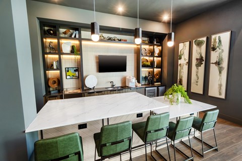 a dining room with a marble table and green chairs