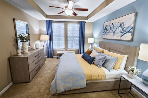 A bedroom with a bed, nightstands, and a ceiling fan.