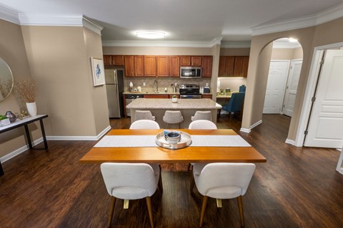 a dining room and kitchen with a wooden table and chairs