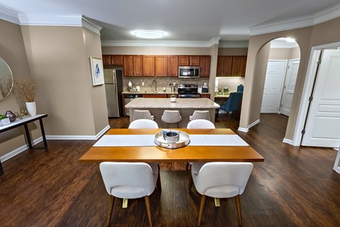 A kitchen with a table and chairs in the foreground.