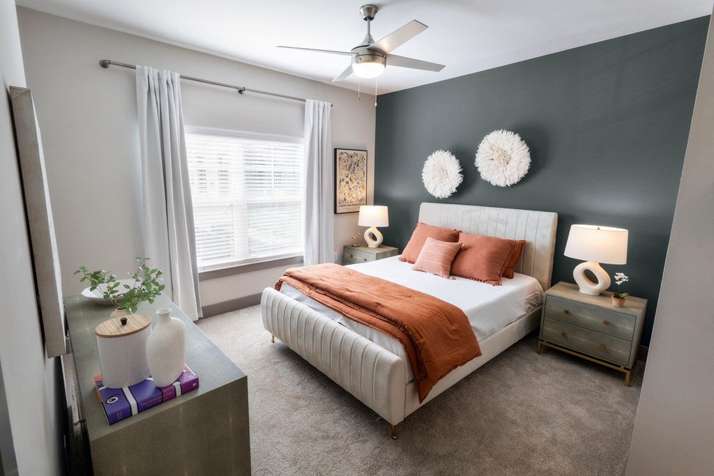 a bedroom with a white bed and a ceiling fan