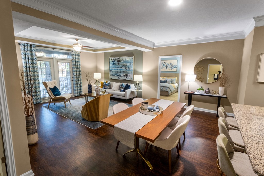 a dining room and living room with a table and chairs at The Reserve at Sugarloaf Apartments, Duluth, GA